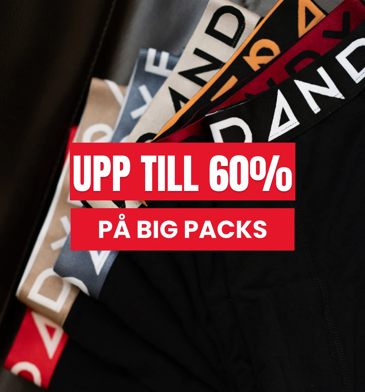 Stack of colorful underwear with visible brand logos, overlaid with a red banner advertising up to 60% off on big packs.